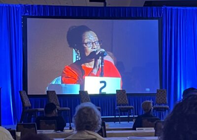 Local 8 member shown on a projector screen speaking on a resolution during the International Convention